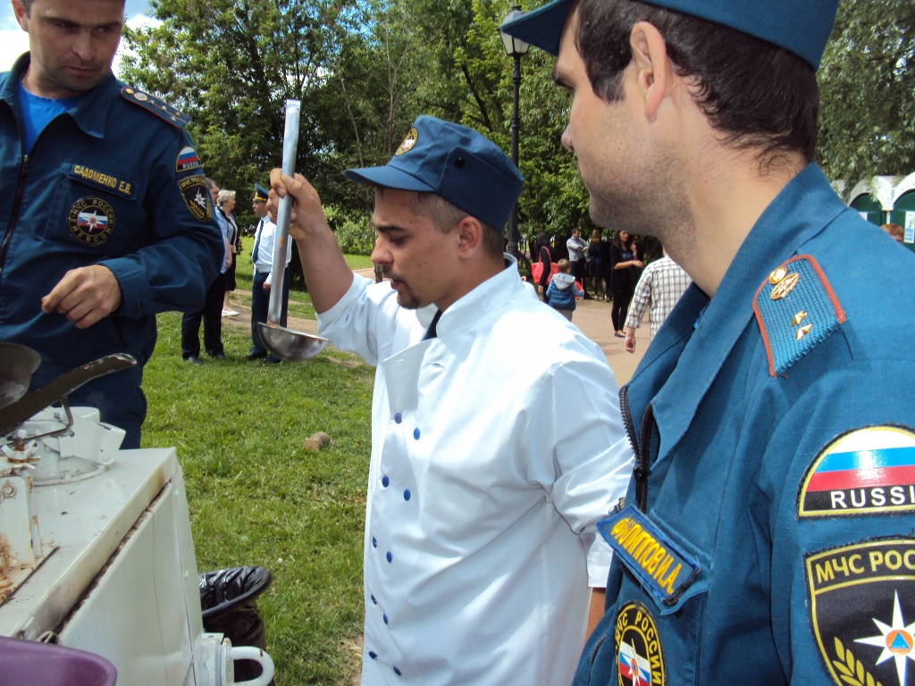 Работники полевой кухни готовят кашу.