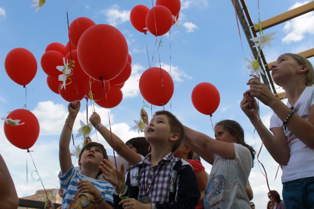 Шары запускать воздух. Дети запускают воздушные шары. Дети запускают шарики в небо. Люди запускающие воздушные шары. Праздник с воздушными шарами.