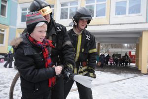 17 февраля 2017 года. Пожарный Александр Салахов показывает школьнику Даниилу Решетневу, как потушить огонь пожарным шлангом. Фото: Пелагия Замятина