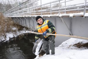 7 декабря 2017 года. Сотрудник Мосводостока Роман Аскеров достает покрышку из реки Городни. Фото: Пелагия Замятина