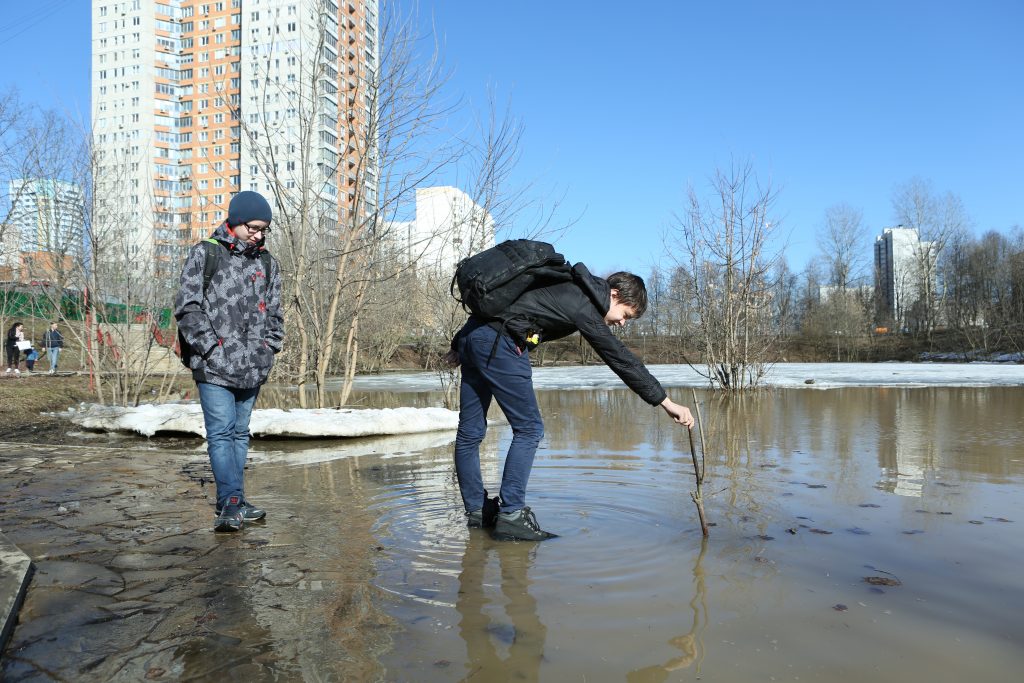 Иван Бондаренко измеряет глубину разлившейся реки. Фото: Алексей Орлов