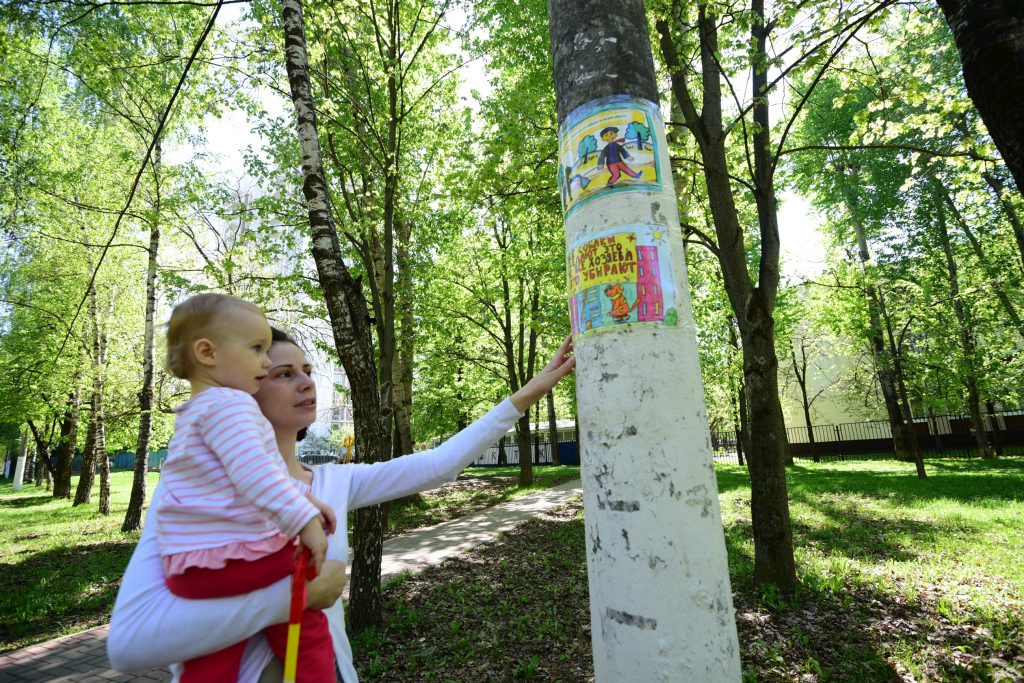 8 мая 2018 года. Жительница района Северное Чертаново Елена Головина показывает своей дочери рисунок, обращенный к владельцам собак. Фото: Пелагия Замятина