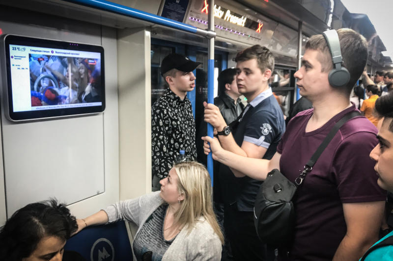 Пассажиры смотрят матч по телевизору в метро. Фото: Павел Волков