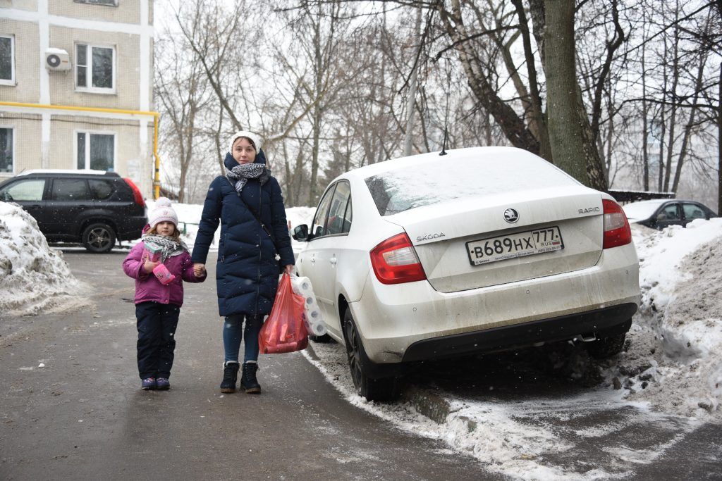 2 февраля 2019 года. Москвичка Светлана Жидова вынуждена идти с дочкой Софьей по проезжей части, так как тротуар у дома на Чертановской улице заставлен автомобилями. Фото: Пелагия Замятина