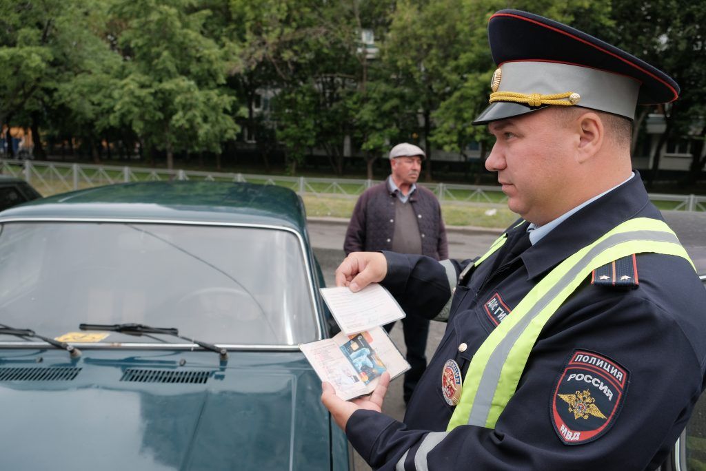 24 мая 2019 года. Лейтенант полиции Владимир Мартынов проверяет документы у водителей, припарковавших свои автомобили на местах, предназначенных для инвалидов. Фото: Максим Аносов