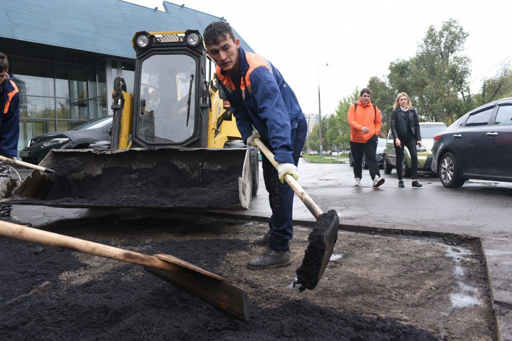 16 августа 2019 года. Сотрудники «Жилищника» Фаррух Намозов (1) и Жамол Жалилов (2) за работой. По просьбе жителей на тротуаре возле дома № 7 по Коломенской улице заменили асфальт. Фото: Пелагия Замятина