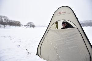 Рыбак Виктор Матвеенко от мороза прячется в палатке. Фото: Пелагия Замятина